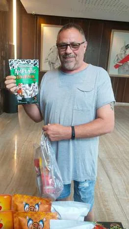 A customer abroad holding a pack of Qisbelin Amplang Kuku Macan