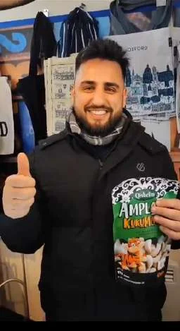A smiling customer giving a thumbs up with Qisbelin Amplang Kuku Macan